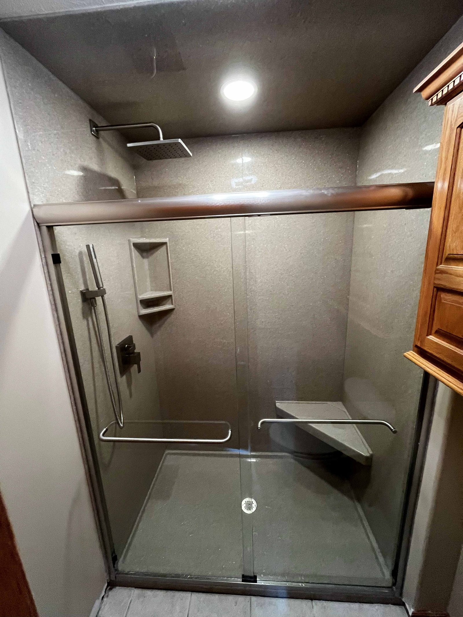 Onyx shower with glass doors, bench and rain head