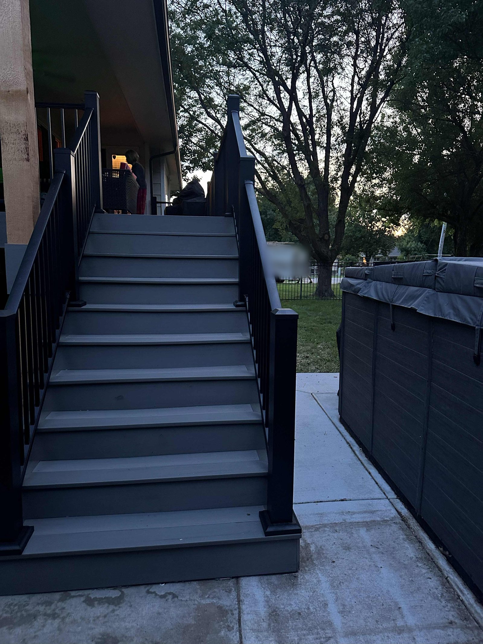 Composite stair treads and risers with black railing, looking up to the deck