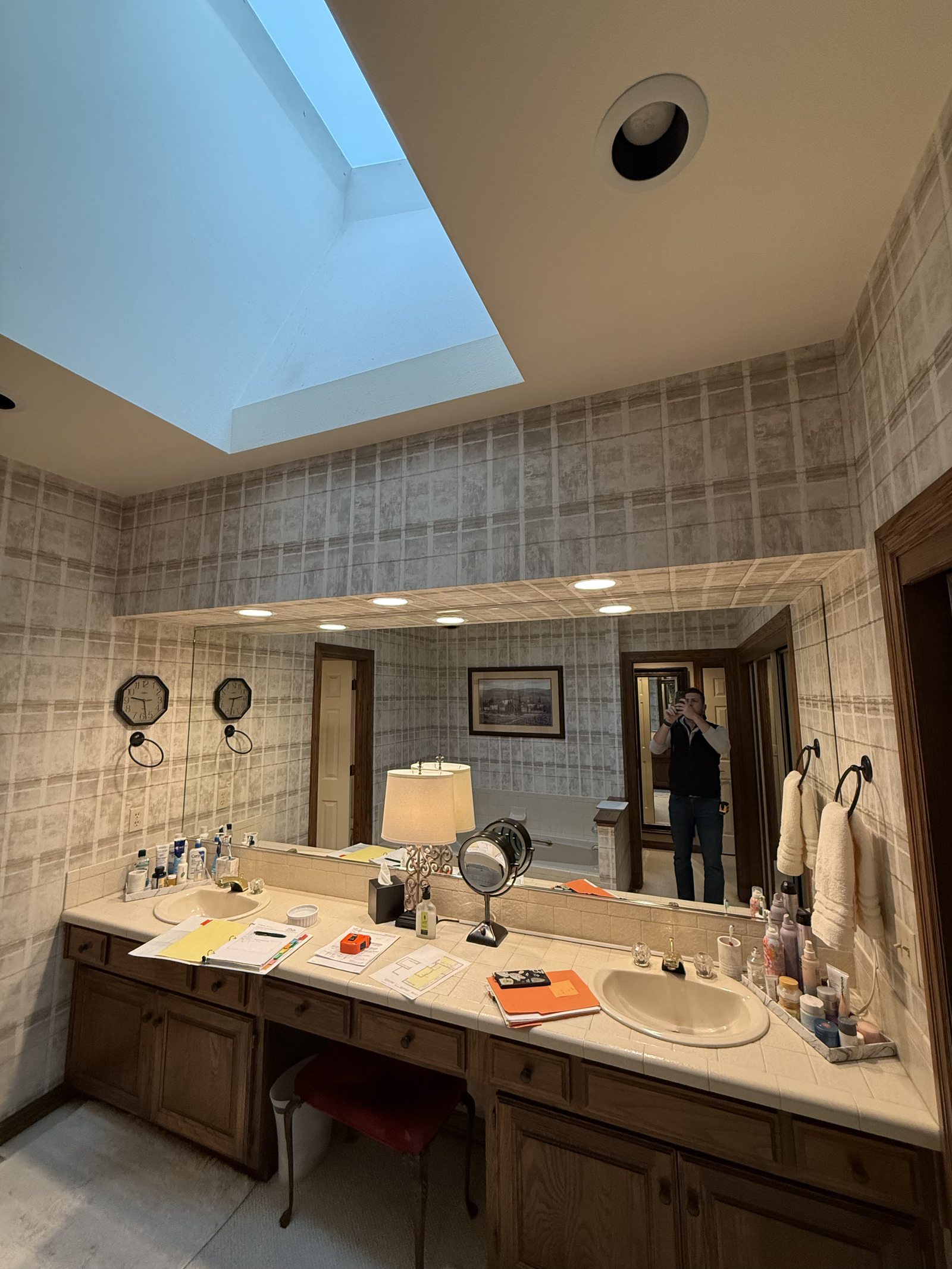 Original bathroom before remodel, dated vanity and wall covering