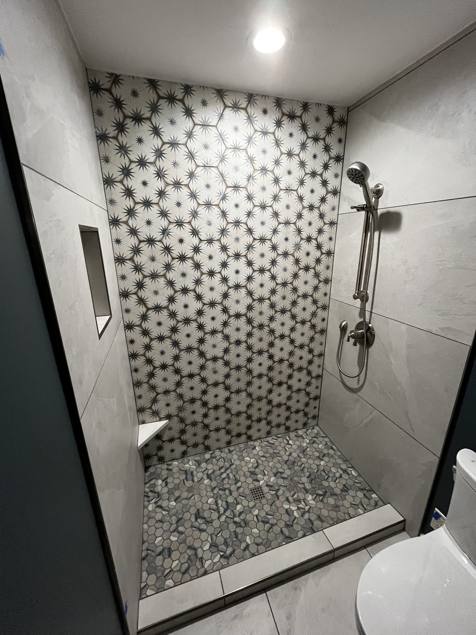 Walk-in shower with niche and glass surround