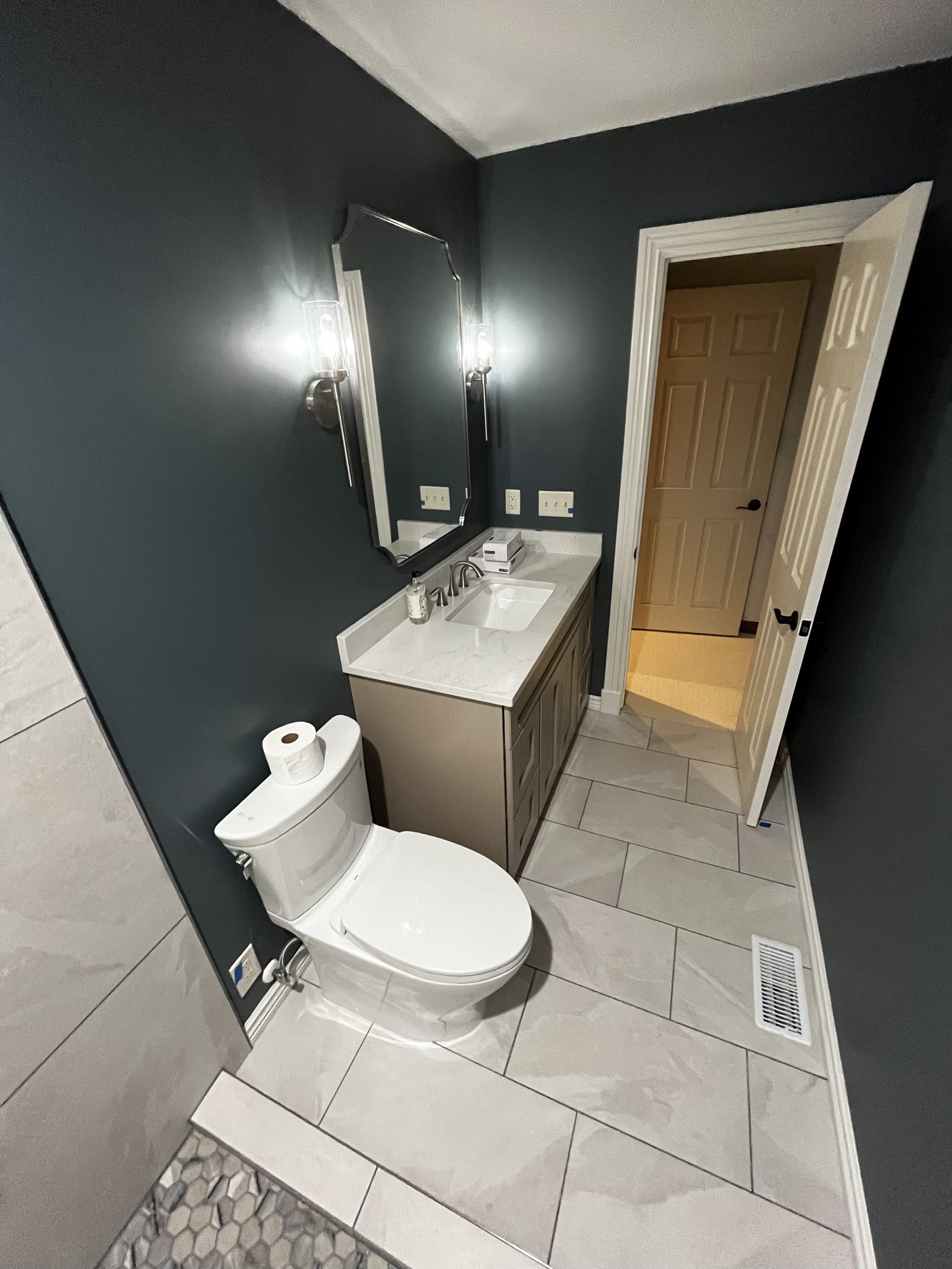 Remodelled bathroom with dark walls, floating vanity and large-format tile